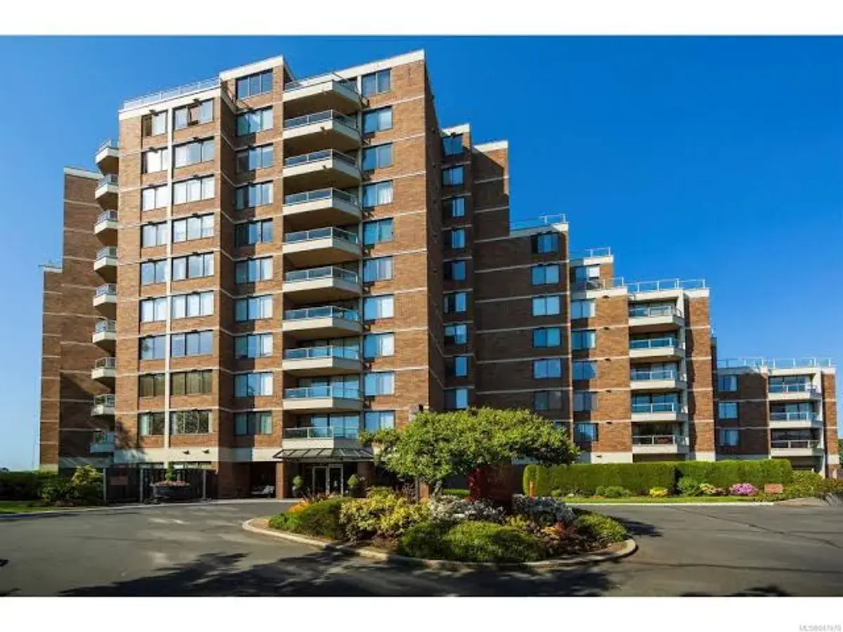 A multi-storey brick strata building with balconies on every floor